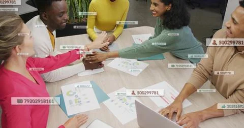 Stacking hands five coworkers joining at meeting table, in colorful tops, Stock Photos