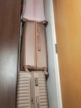 Stacking luggage efficiently in a narrow space to maximize organization and Stock Photos