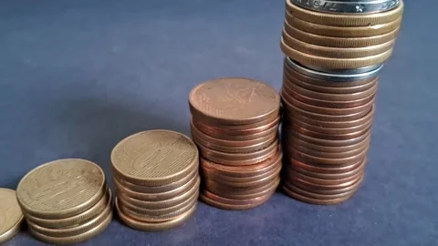 Stacking metal coins increasing in height representing growth Stock Footage 345448501