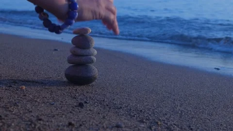 Stacking pebbles on the shore. 4K Stock Footage 195653648