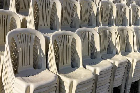 Stacking plastic chairs for a large outdoor event Stock Photos