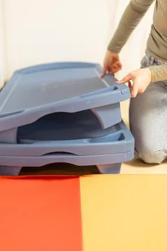 Stacking plastic storage bins during an organization project in a home setting Foto stock