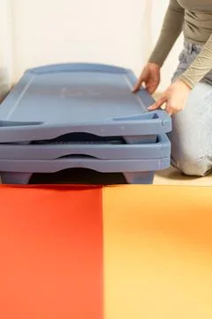 Stacking plastic storage containers in a home environment during a decluttering Stock Photos