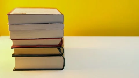 Stacking reading books stop motion on yellow background Stock Footage 169513115