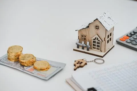 Stacking of US Dollar bank notes , model house, contract agreement on desk. R Stock Photos