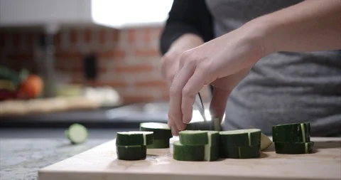 Stacking up zucchini to be sliced for a dish Stock Footage 98191610