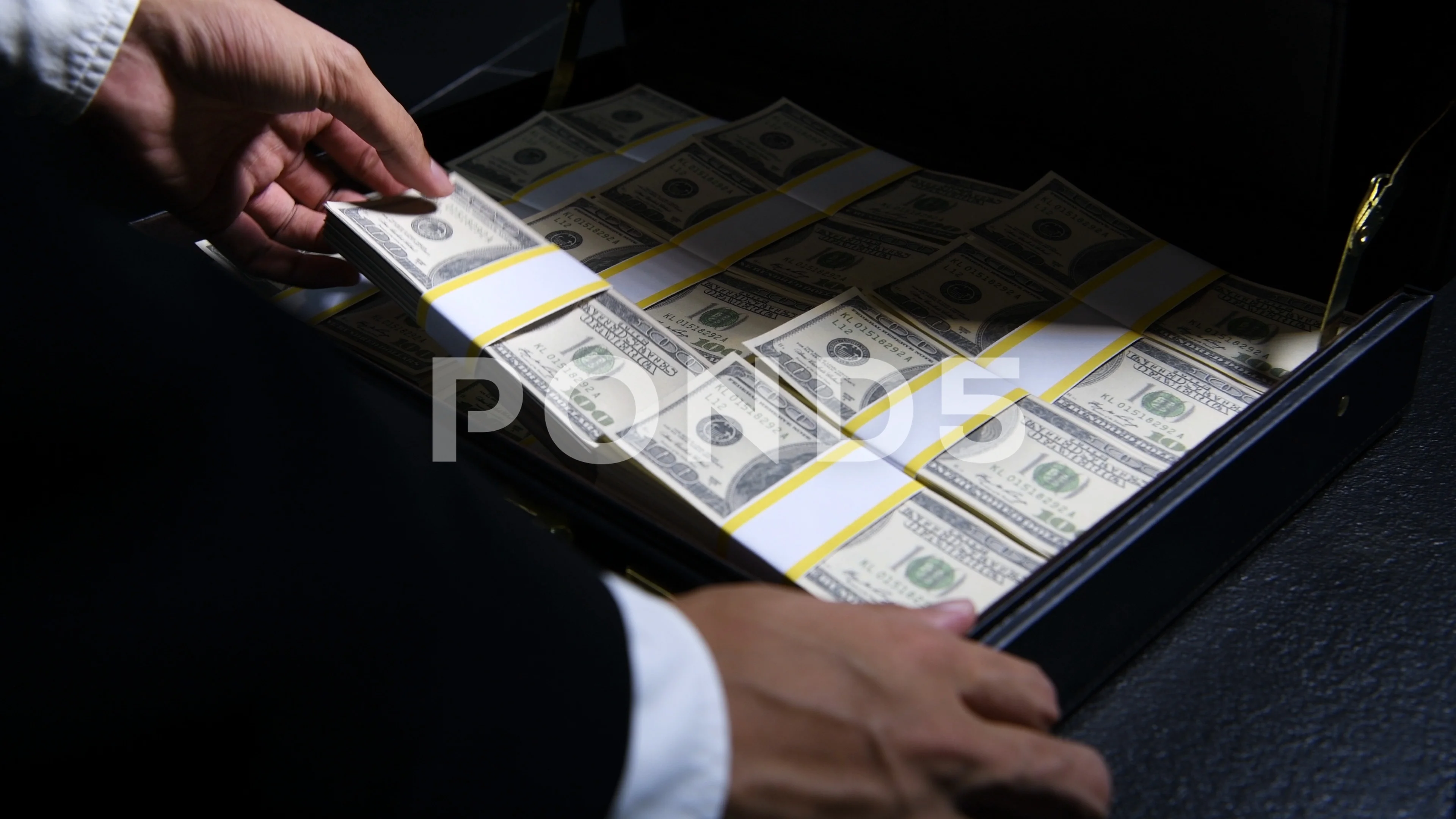 Black Businessman holding black bag full of US dollar notes