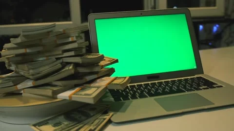 Stacks 100 US dollars bills lying on rotating surface and laptop with chromakey Stock Footage 248101345