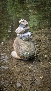 Stacks of balanced river pebbles on the water’s edge Stock Photos