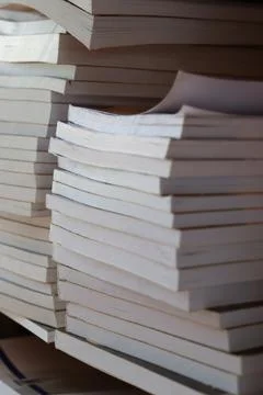 Stacks of books on a shelf in a library during daytime near a window Photos