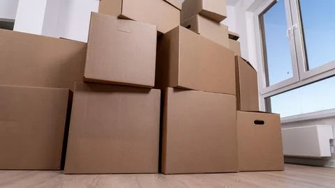 Stacks of brown cardboard boxes fill the room Stock Photos