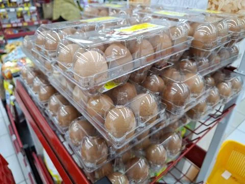 Stacks of Brown Eggs in Clear Plastic Packaging at a Supermarket Foto stock
