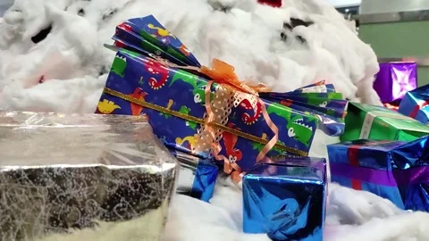 Stacks of Christmas gift boxes with dinosaur decorations on the floor Stock Footage 261025996