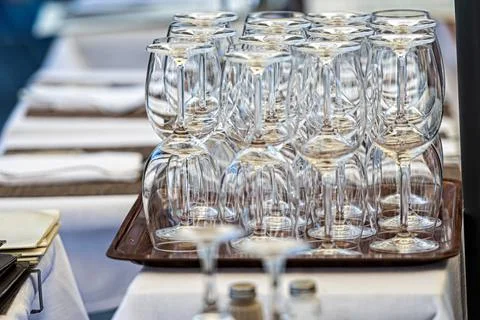 Stacks of clean empty glasses on trays in a street cafe, closeup Foto stock