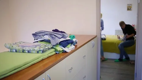 Stacks of clothes on closet in corridor, in room parents dress baby Stock Footage 79973004
