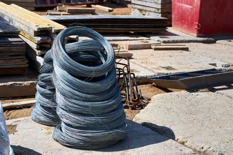 Stacks of coiled steel binding wire on a busy construction site, essential .. Fotos de archivo