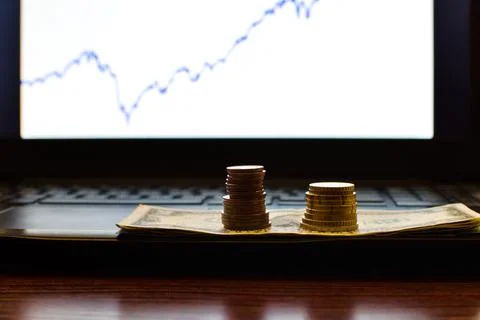 Stacks of coins on blurred computer screen Foto stock
