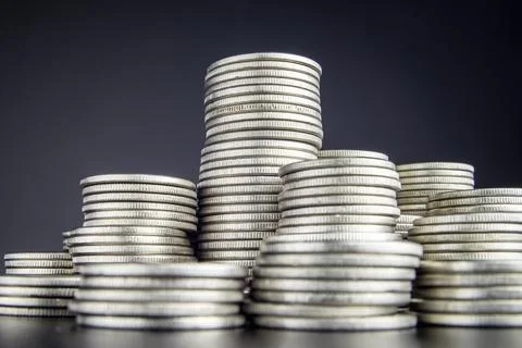 Stacks of coins different height close up in front of the camera Stock Photos