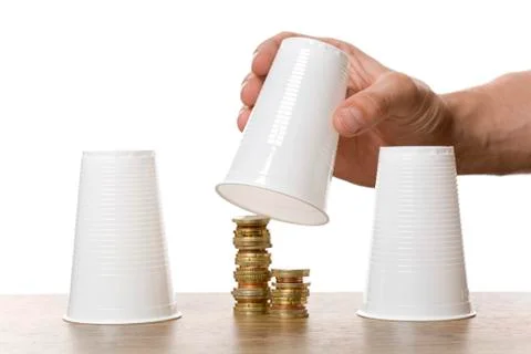 Stacks of coins under plastic drinking cups, gambling Stock Photos