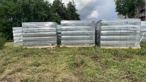 Stacks of concrete paving slabs wrapped in plastic on wooden pallets  Stock-Footage 340997698