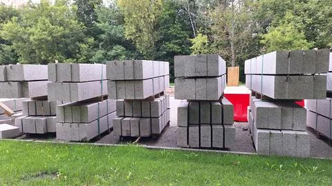 Stacks of construction concrete blocks on grass with forest background Stock Photos