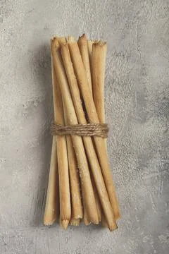 Stacks of crispy bread sticks tied with twine on a textured background Foto stock