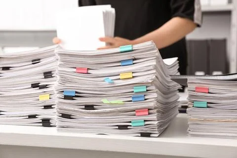 Stacks of documents with paper clips on office desk Stock Photos