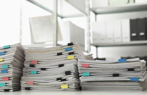 Stacks of documents with paper clips on office desk Stock Photos
