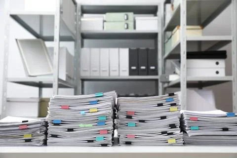 Stacks of documents with paper clips on office desk Stock Photos