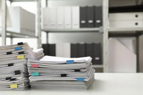 Stacks of documents with paper clips on office desk. Space for text Stock Photos