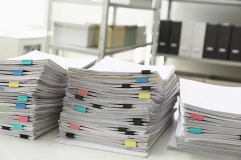 Stacks of documents with paper clips on office desk Stock Photos