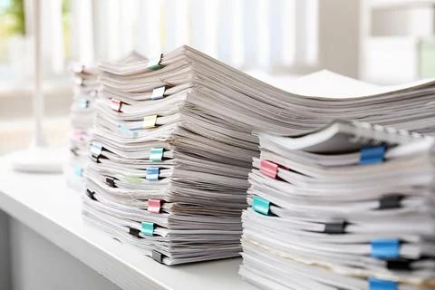 Stacks of documents with paper clips on office desk Stock Photos