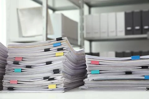 Stacks of documents with paper clips on office desk Stock Photos