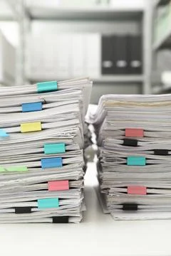 Stacks of documents with paper clips on office desk Stock Photos