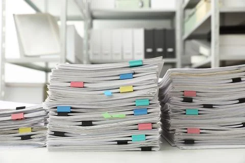 Stacks of documents with paper clips on office desk Stock Photos