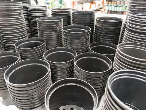 Stacks of empty black plastic plant pots Stock Photos