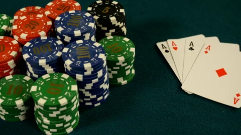 Stacks of gambling chips and four of a kind cards on aces on casino table Stock Footage 221420597