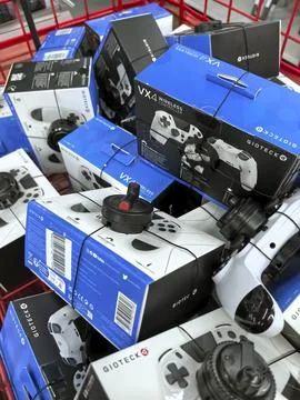 Stacks of gaming controllers ready for purchase in a retail environment Stock Photos