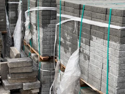 Stacks of gray cobblestone blocks secured with plastic wrap and ropes. Stockfoto's