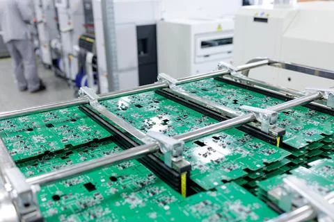 Stacks of green circuit boards in rack at modern electronics factory line Stock Photos