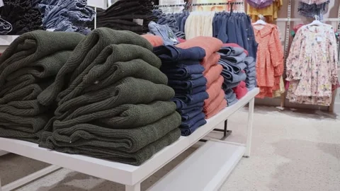 Stacks of knitted wool sweaters in different colours lie on the shelf. Stock Footage 211120367