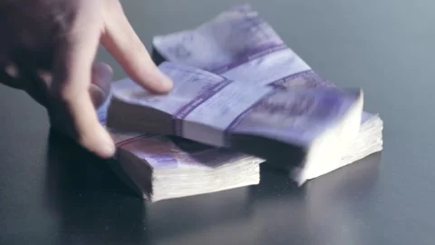 Stacks of money fall onto the table Stock Footage 284444984