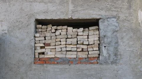 Stacks of old bricks in a square window in an abandoned house Stock Photos
