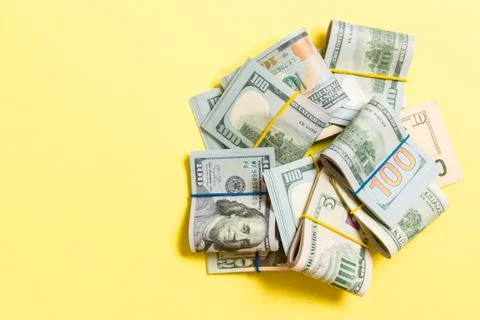 Stacks of one hundred dollars banknotes close-up on colored background busine Stock Photos
