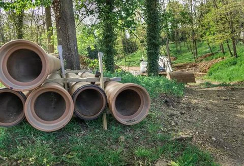 Stacks of orange and gray plastic pipes at a construction site in France. Stock-Fotos