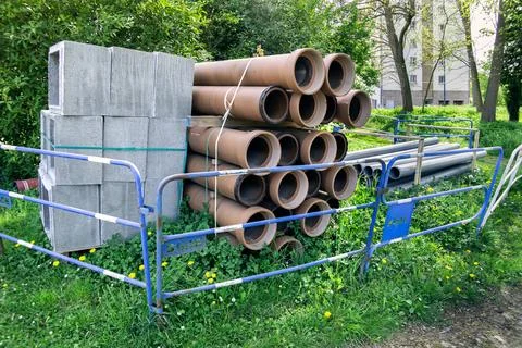 Stacks of orange and gray plastic pipes at a construction site in France. 库存照片