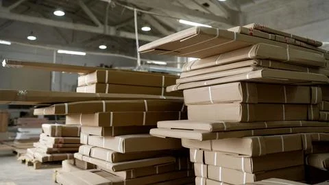 Stacks of packed cardboard boxes with flat-pack furniture in a large indust.. Foto stock