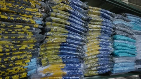 Stacks of packed clothes on shelves. Wrapped textile lots in stock. Textile Stock Footage 272267264