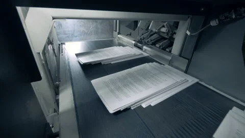 Stacks of paper with printed text are moving along the conveyor belt Stock Footage 105151642