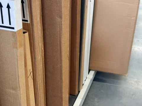 Stacks of plain brown cardboard boxes on pallets inside a retail supermarke.. Stock Photos